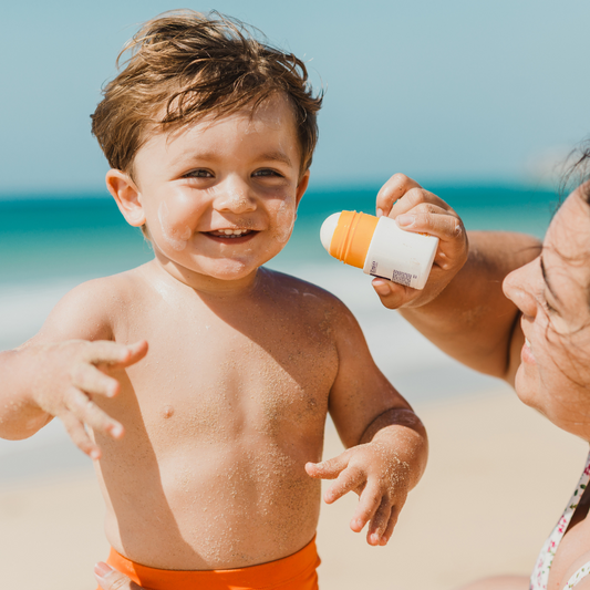 Toddler getting sunscreen on his face