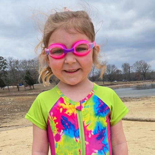 Girl in tie dye swimsuit and pink goggles