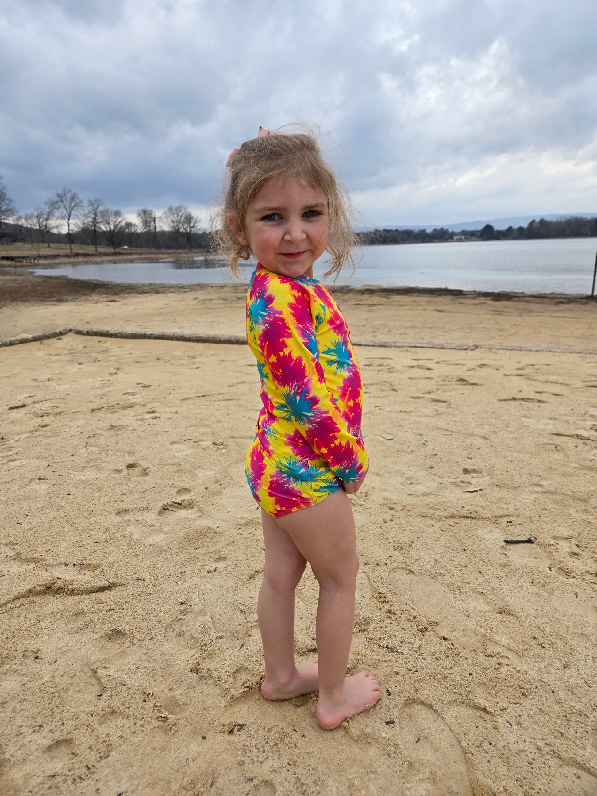 Toddler girl in neon long sleeve rash guard at the lake
